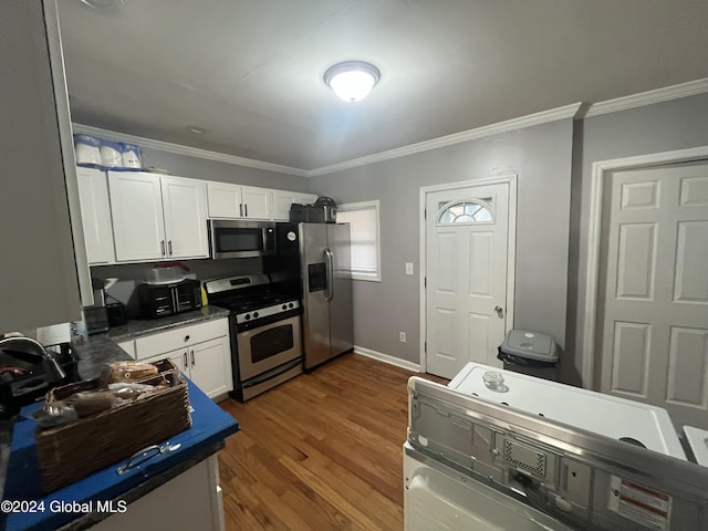 kitchen with crown molding, dark wood-type flooring, white cabinets, and stainless steel appliances