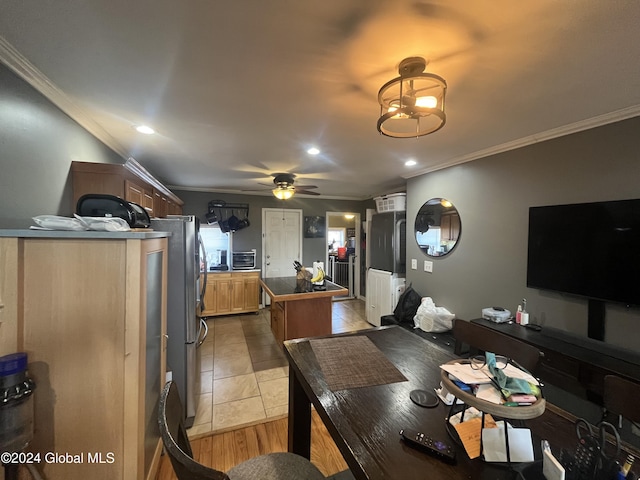 dining room featuring light wood-type flooring, ceiling fan, and crown molding