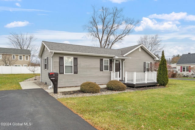 view of front of property with a wooden deck and a front lawn