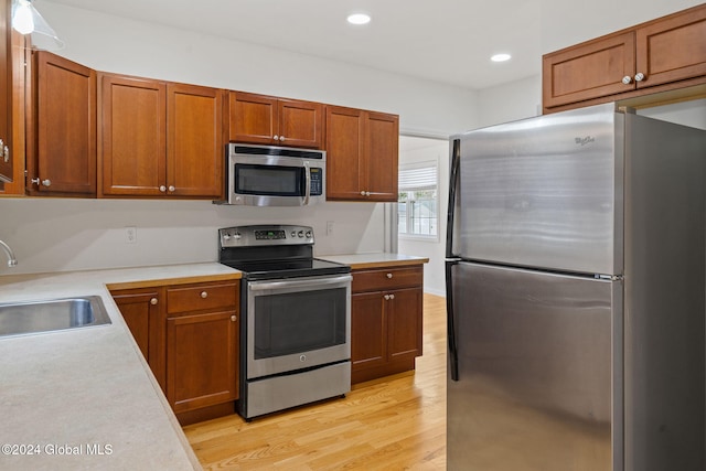 kitchen featuring sink, stainless steel appliances, and light wood-type flooring