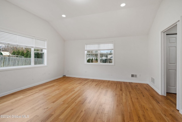 unfurnished bedroom with light hardwood / wood-style floors and lofted ceiling