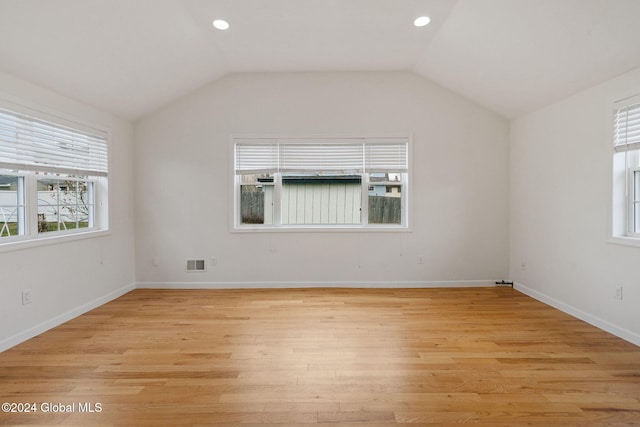 unfurnished room featuring light wood-type flooring and vaulted ceiling