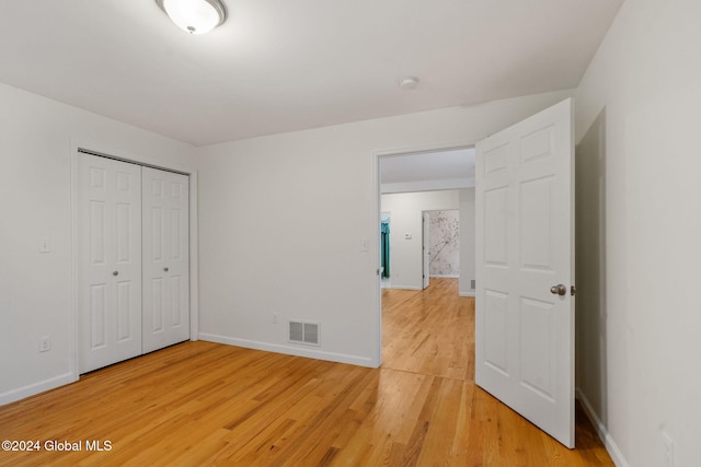 unfurnished bedroom with a closet and hardwood / wood-style floors