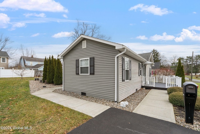 view of property exterior featuring a yard and a deck