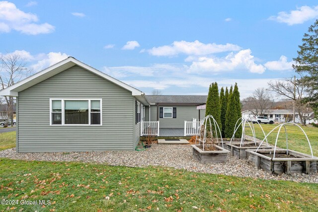 rear view of property with a deck and a lawn