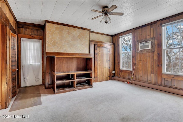 unfurnished living room featuring light carpet, ceiling fan, and wooden walls