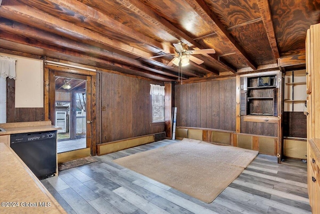 interior space featuring beam ceiling, wood walls, ceiling fan, and light hardwood / wood-style floors