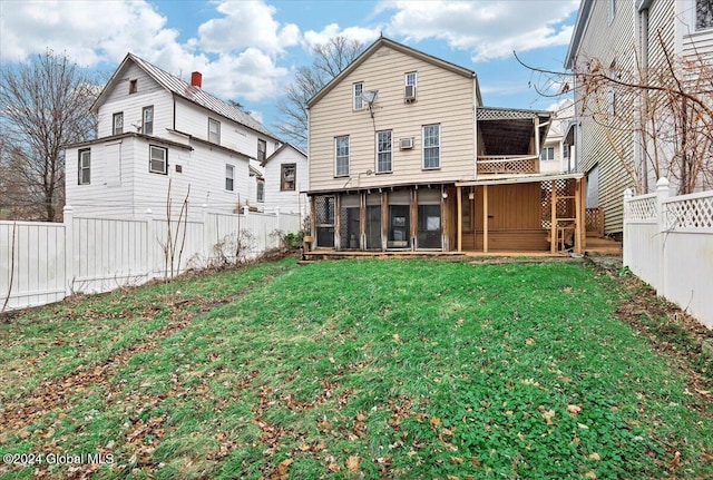 rear view of house with a yard and a sunroom