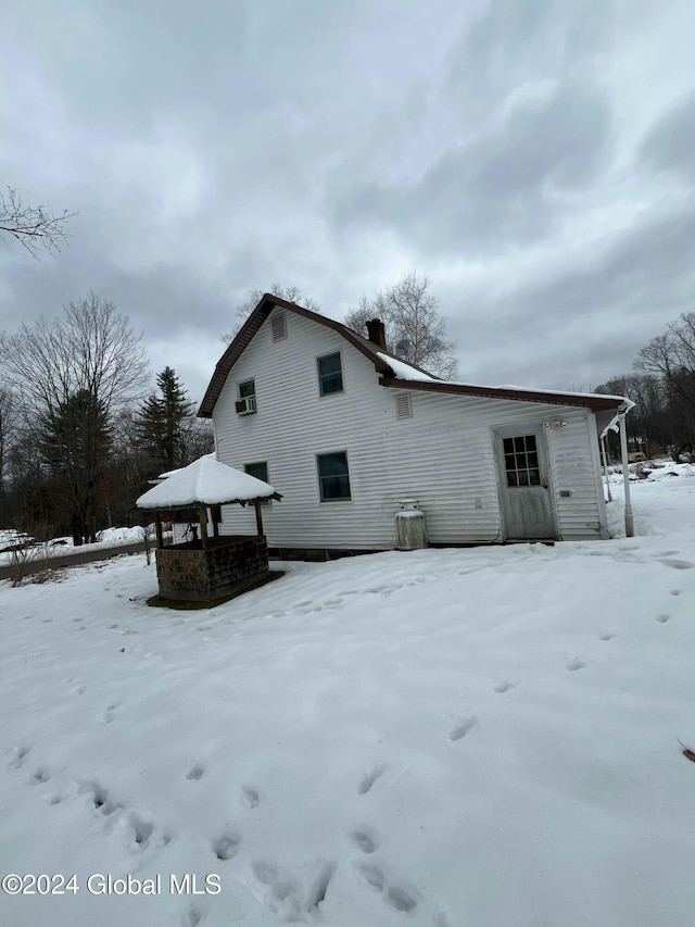 snow covered rear of property with cooling unit