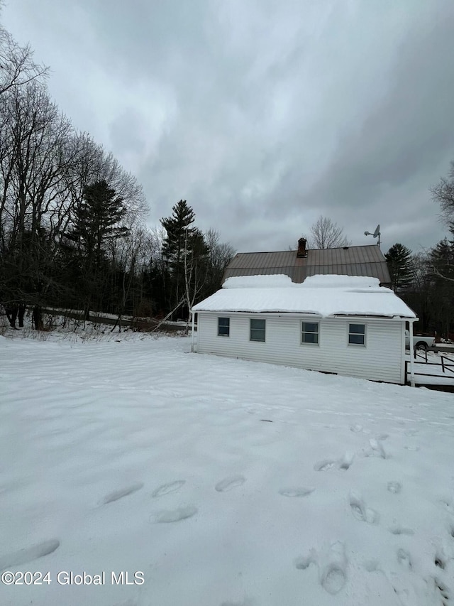 view of snow covered rear of property