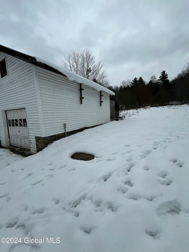 view of snow covered exterior featuring a garage