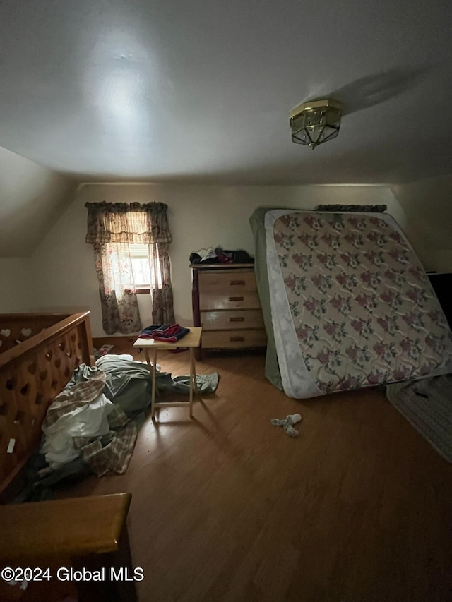 bedroom with vaulted ceiling and hardwood / wood-style flooring