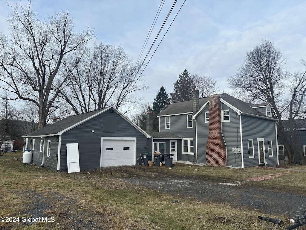 view of front facade featuring a garage and an outbuilding