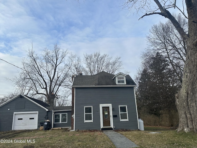 view of front of house with a front yard, a garage, and an outdoor structure