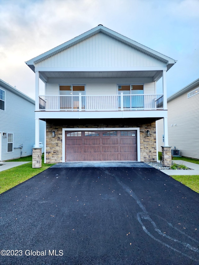 view of front of property with central AC unit, a garage, and a balcony