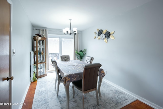 dining space featuring hardwood / wood-style floors and an inviting chandelier