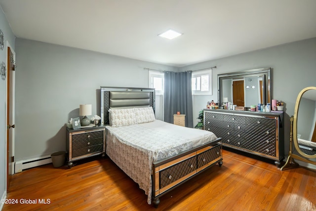 bedroom featuring hardwood / wood-style floors and a baseboard radiator