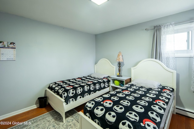 bedroom with hardwood / wood-style floors and a baseboard radiator