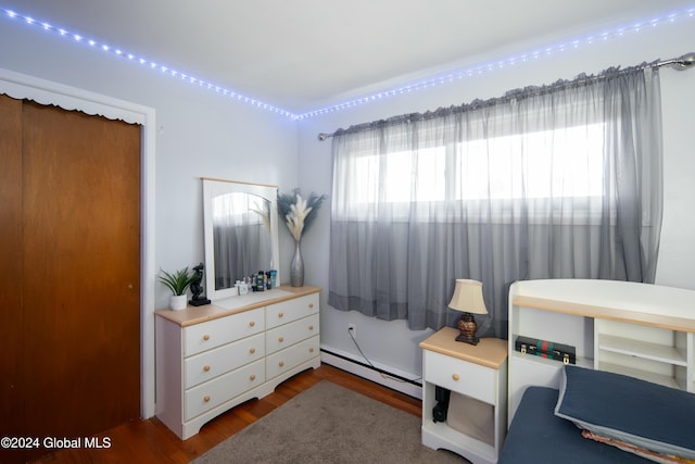 bedroom with hardwood / wood-style flooring and a baseboard radiator