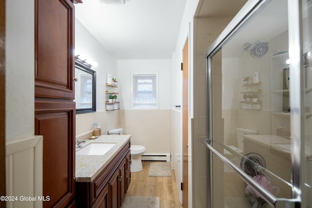 bathroom featuring walk in shower, vanity, hardwood / wood-style flooring, a baseboard radiator, and toilet