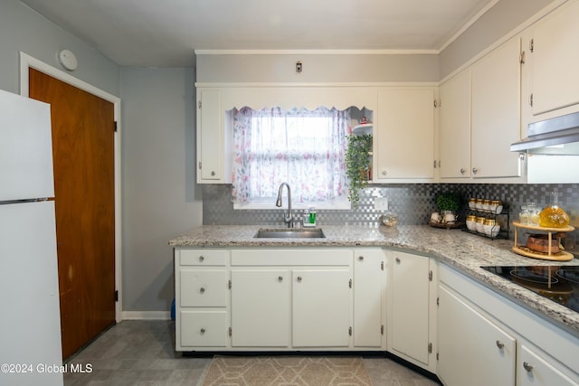 kitchen with backsplash, white refrigerator, sink, black electric cooktop, and white cabinetry