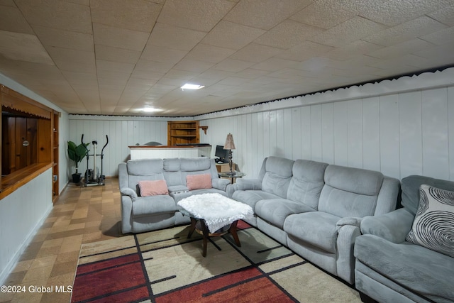 living room with bar area and wood walls