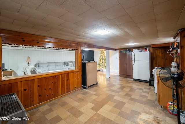 kitchen with wood walls and white fridge