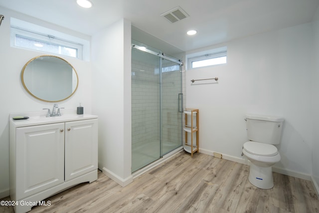 bathroom featuring toilet, hardwood / wood-style floors, vanity, and walk in shower