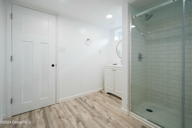 bathroom with hardwood / wood-style flooring, vanity, and walk in shower