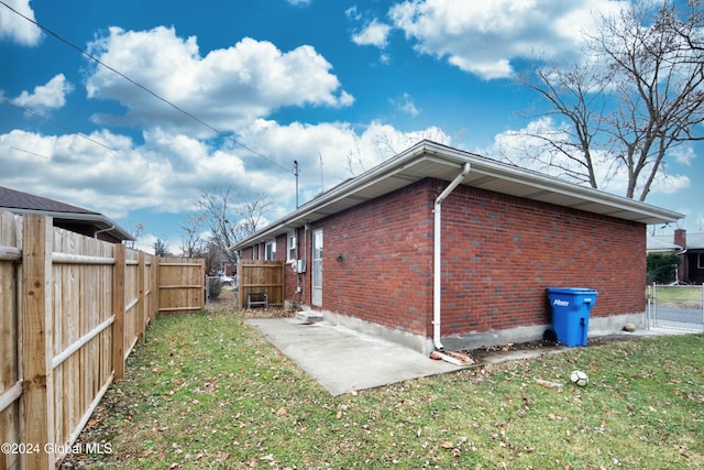 view of side of property with a yard and a patio area