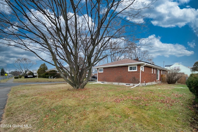 view of side of home with a yard