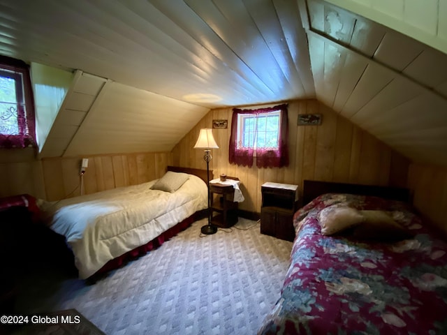 bedroom featuring light colored carpet, vaulted ceiling, and wood walls