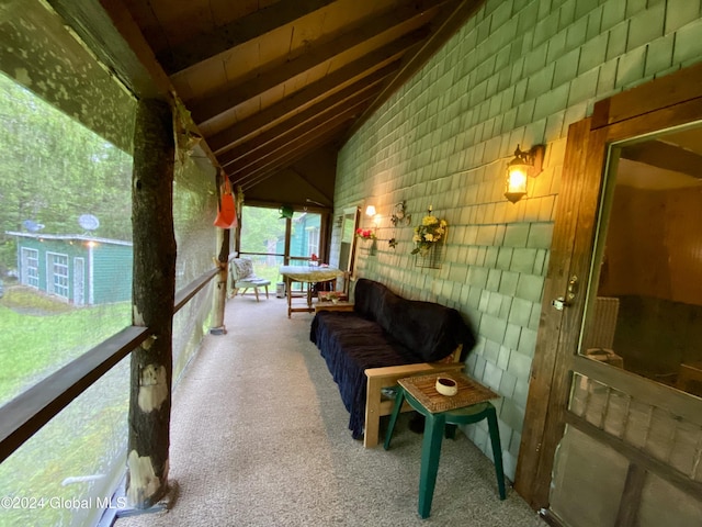 unfurnished sunroom with lofted ceiling with beams