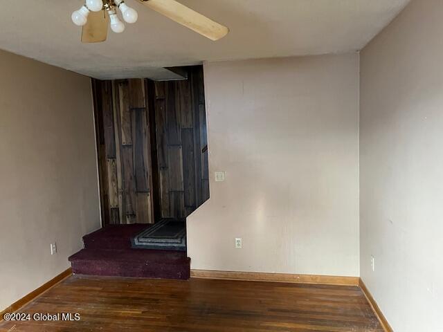 unfurnished room featuring ceiling fan and dark wood-type flooring