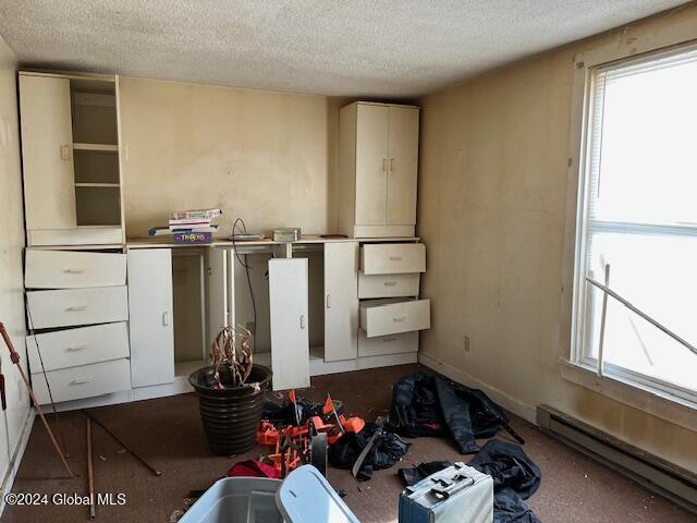 bedroom featuring a textured ceiling and baseboard heating