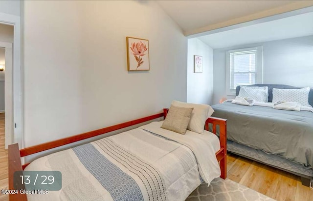 bedroom with lofted ceiling and wood-type flooring