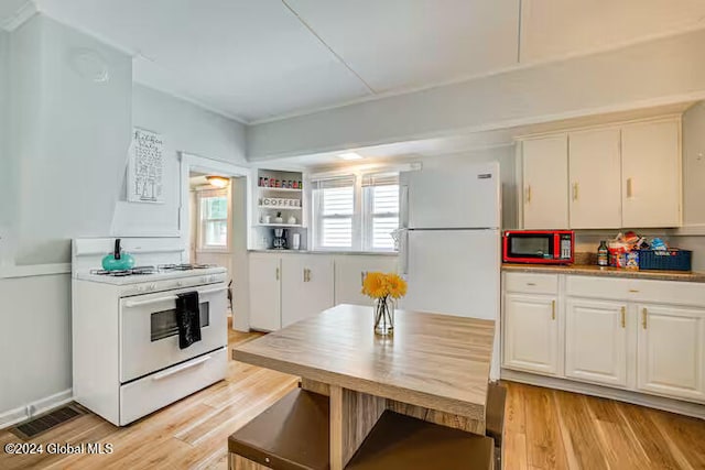 kitchen featuring white appliances, light hardwood / wood-style floors, and white cabinets