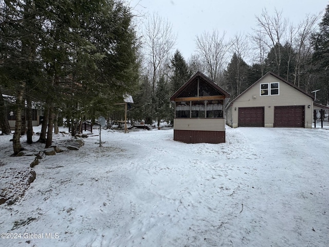 yard covered in snow featuring an outbuilding and a garage