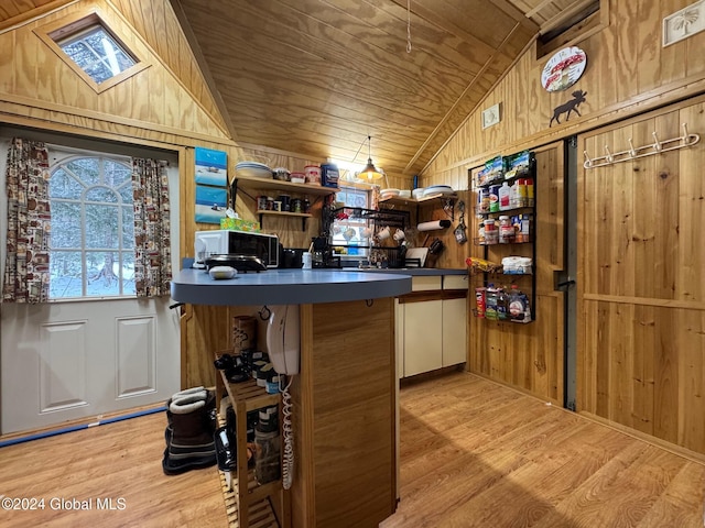 kitchen featuring wooden ceiling, kitchen peninsula, light hardwood / wood-style floors, lofted ceiling, and wooden walls