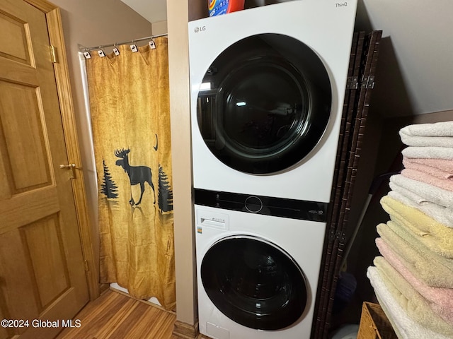 washroom with light hardwood / wood-style flooring and stacked washer and clothes dryer