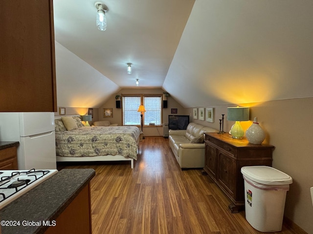 bedroom featuring white refrigerator, dark hardwood / wood-style flooring, and lofted ceiling