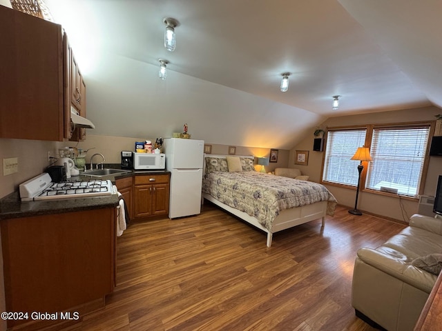 bedroom with dark hardwood / wood-style flooring, sink, white fridge, and lofted ceiling