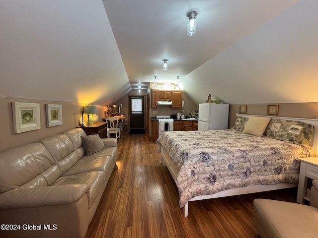 bedroom with dark hardwood / wood-style flooring, white fridge, lofted ceiling, and sink