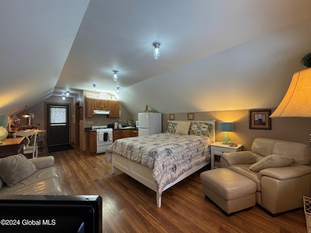 bedroom with vaulted ceiling, white fridge, and dark hardwood / wood-style floors