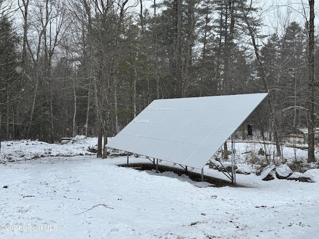 snow covered structure featuring solar panels