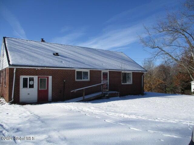 view of snow covered back of property