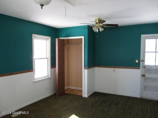 unfurnished bedroom featuring ceiling fan and a closet