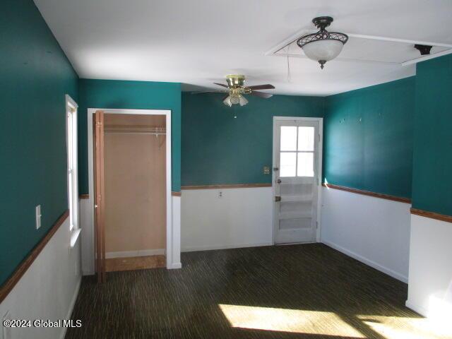 carpeted spare room with ceiling fan