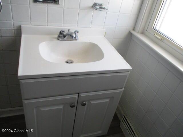 bathroom with vanity and tile walls