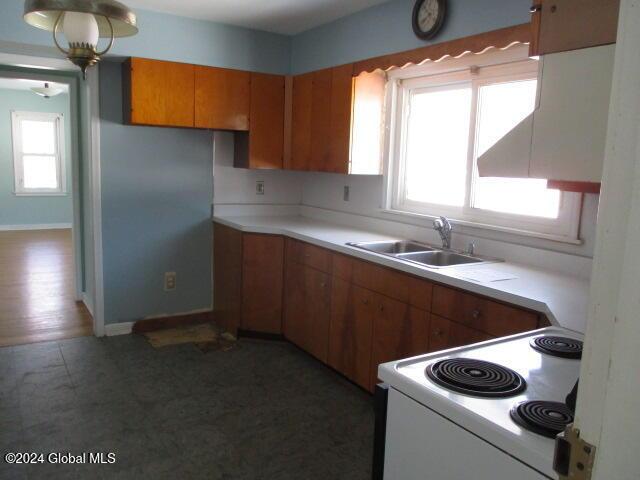 kitchen featuring dark hardwood / wood-style flooring, white electric range, and sink